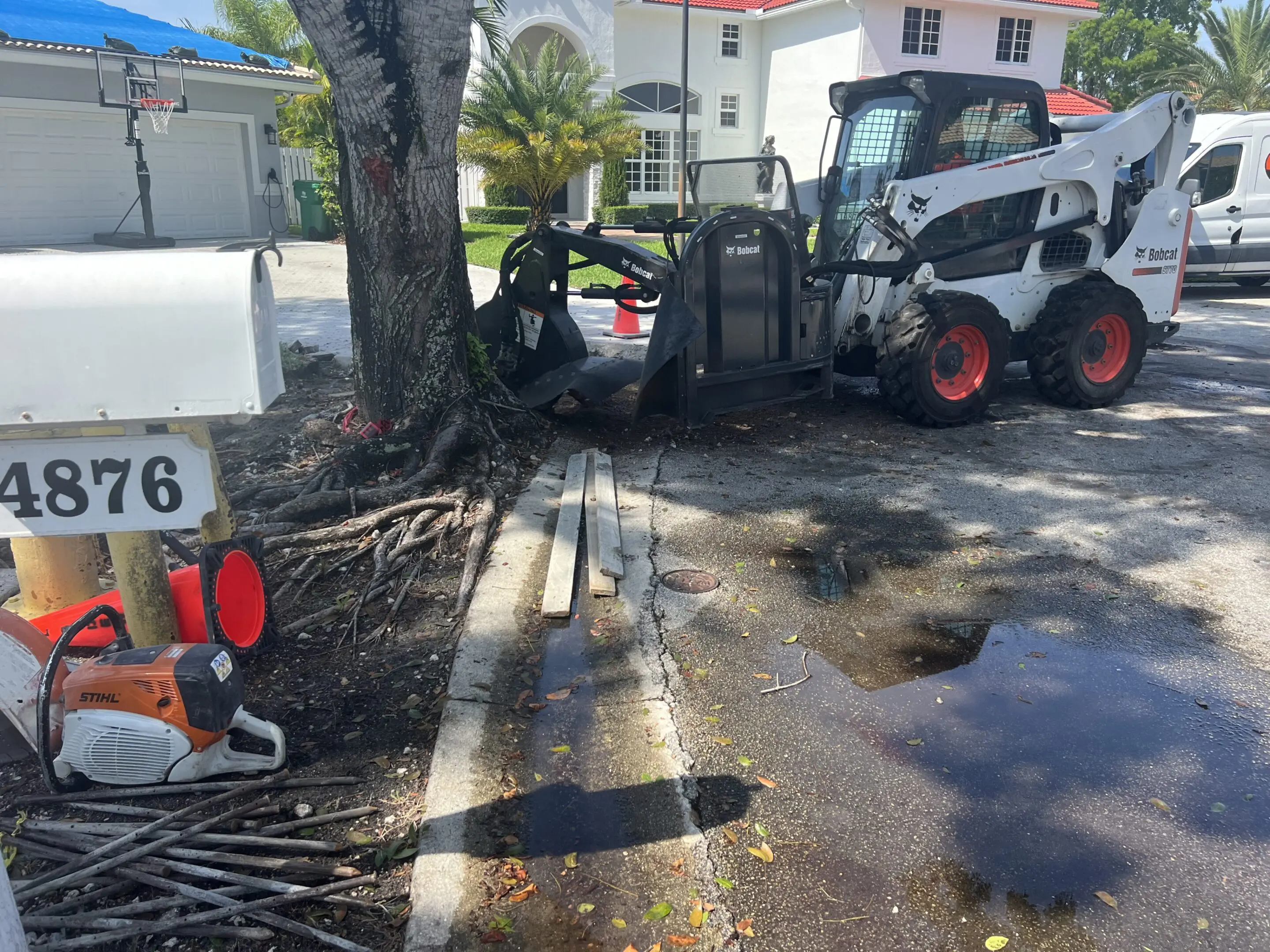 A white and black tractor parked on the side of road.